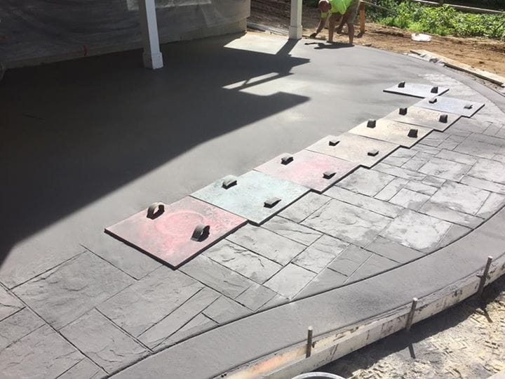 Hand-stamping a stone pattern into fresh concrete